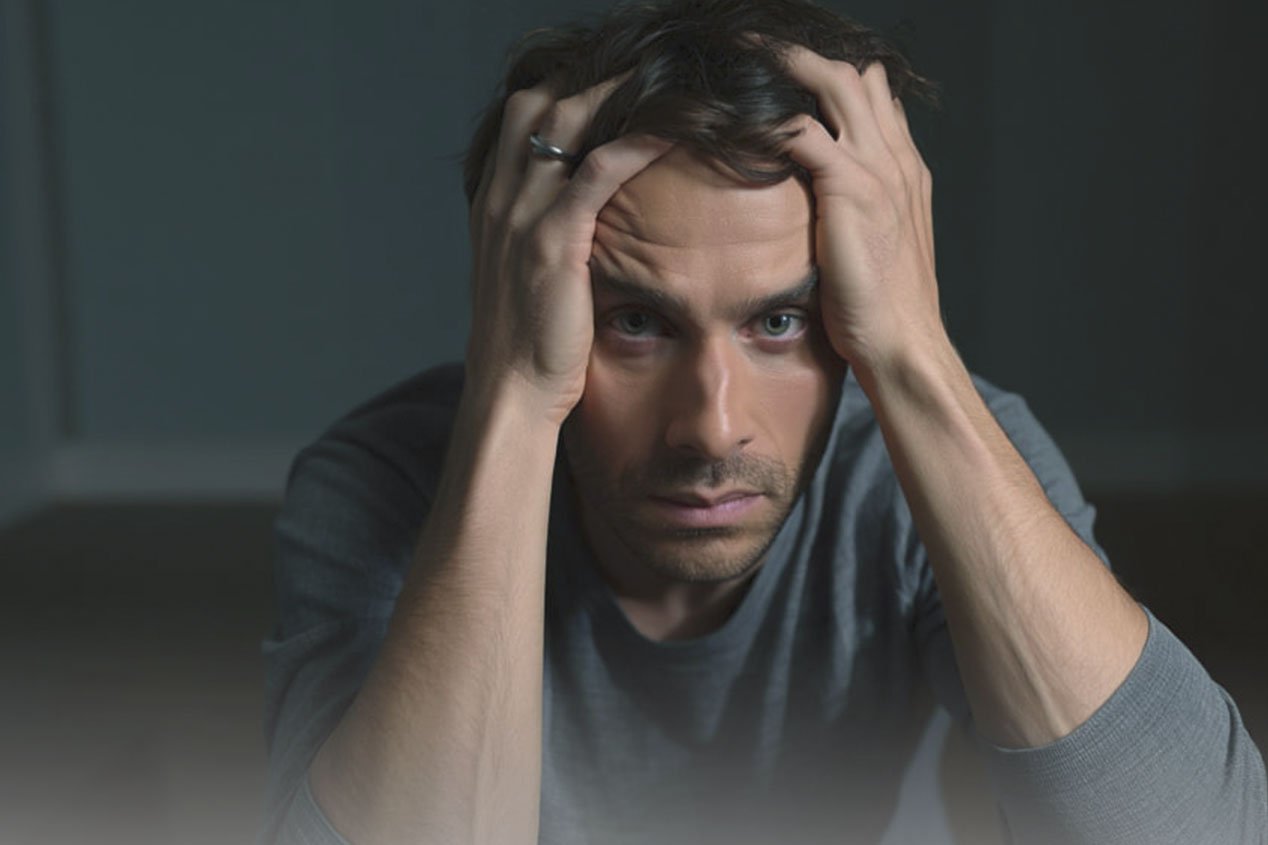 Психозы у мужчины Мужчина держится руками за голову